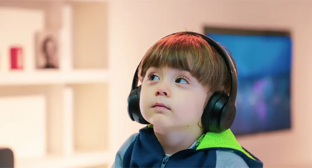 Young boy with Autism wearing headphones during a virtual speech therapy session