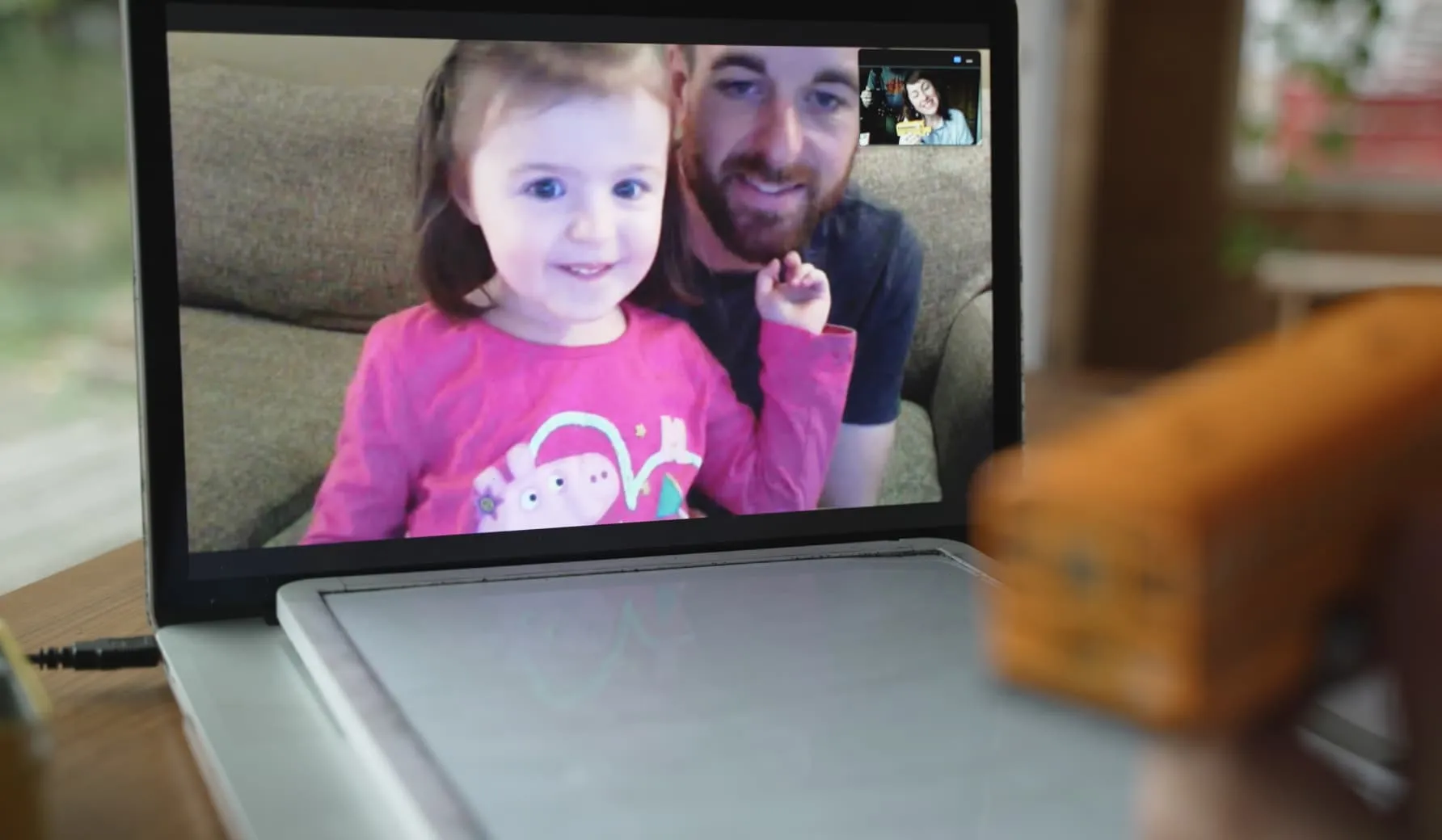 An online speech therapy session being conducted by Heather on a Zoom video call with a toddler and her dad.